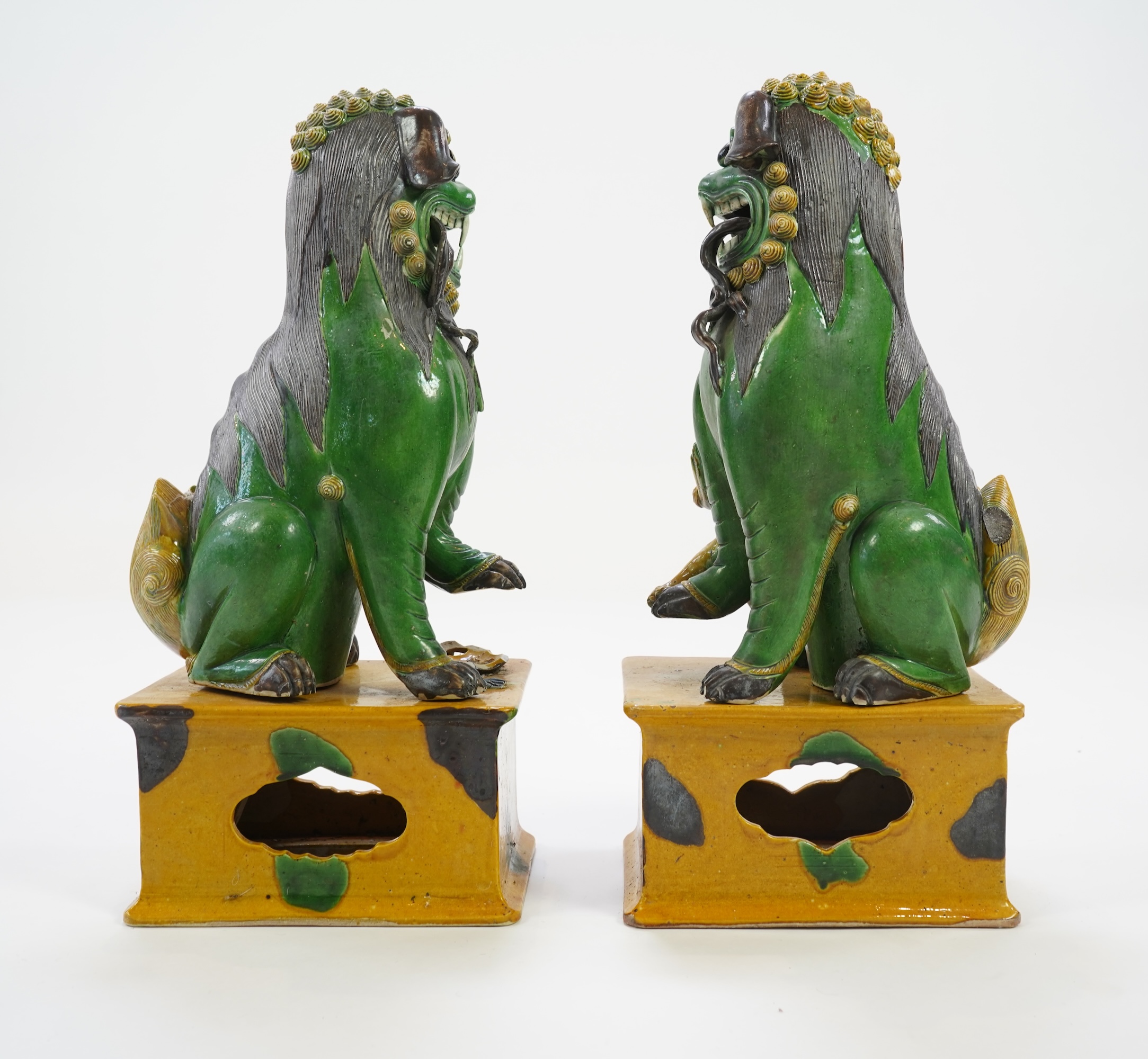 A pair of large Chinese sancai-glazed biscuit figures of Buddhist temple lions, 19th century